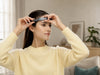 Woman adjusting the SereniBrain EEG headband for a comfortable fit